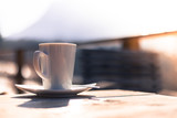 Cup of coffee on the table of a café, outdoors in the sunny afternoon. Blurry background.