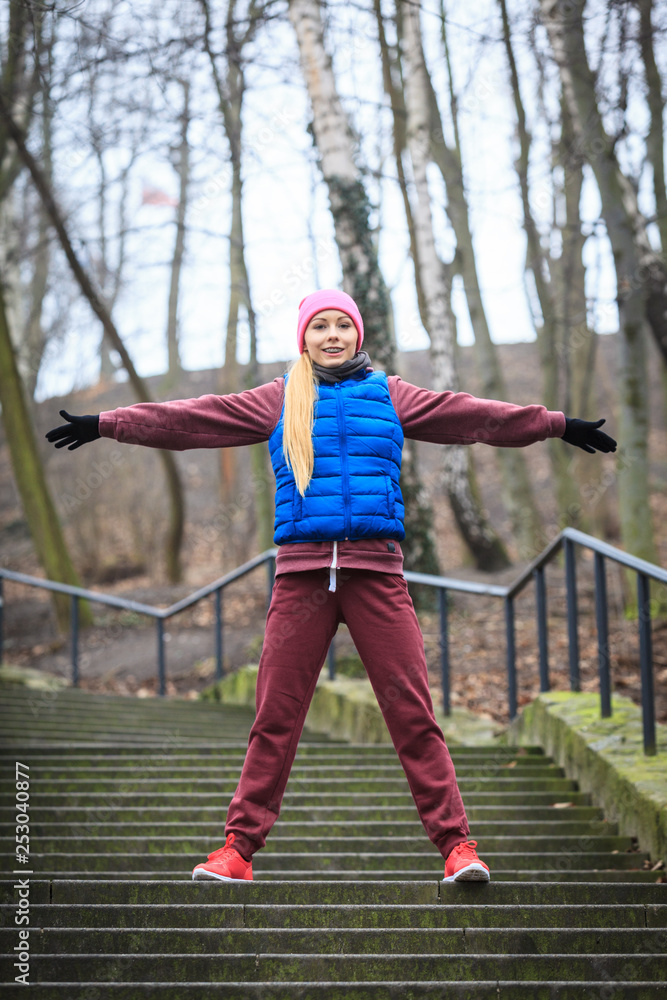 Woman wearing sportswear exercising outside during autumn