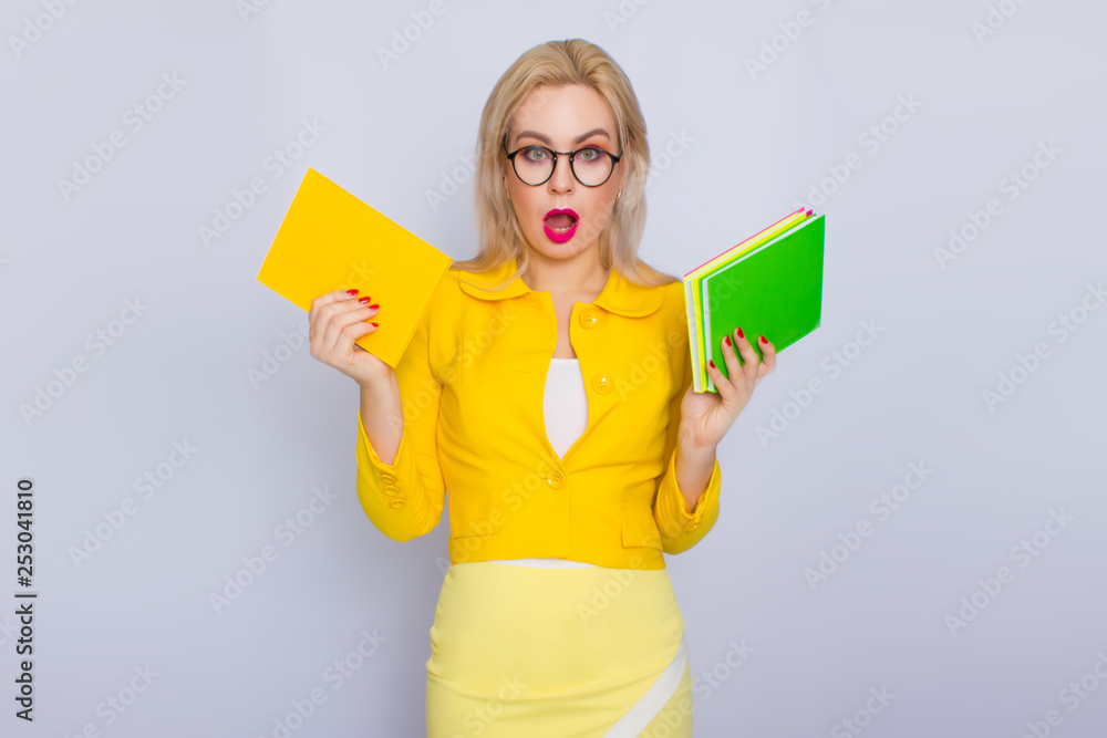 Woman in yellow suit holding books in her hands Woman in yellow suit holding books in her hands