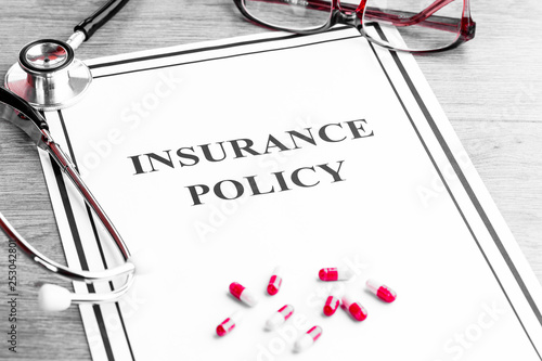 Insurance policy. Medical stethoscope, glasses and dollars on wooden table. Business and medical background concept