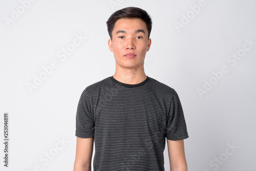 Face of young handsome Asian man against white background