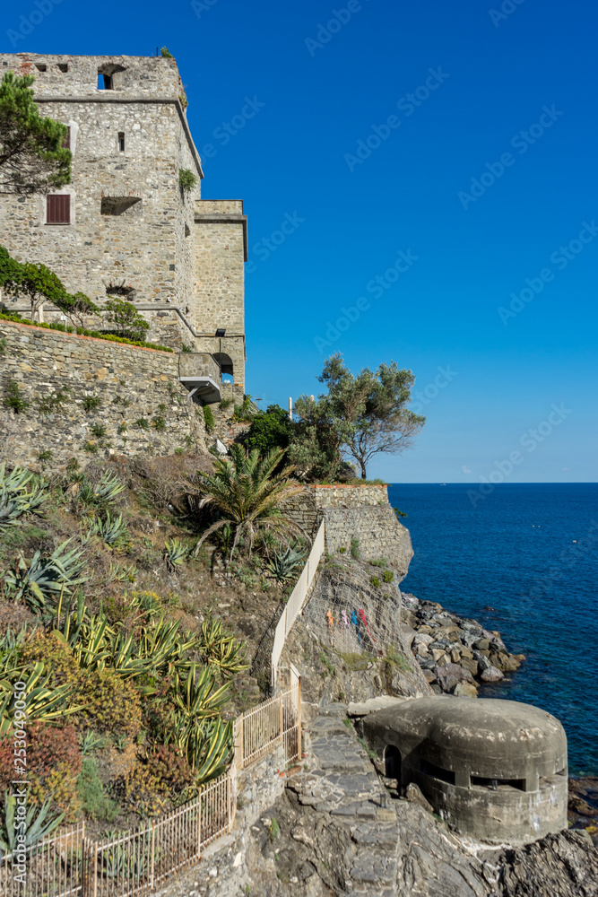 Italy, Cinque Terre, Monterosso, a stone castle next to a rock