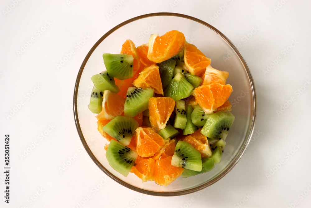 Tropical fruit salad in a salad bowl on a white background.