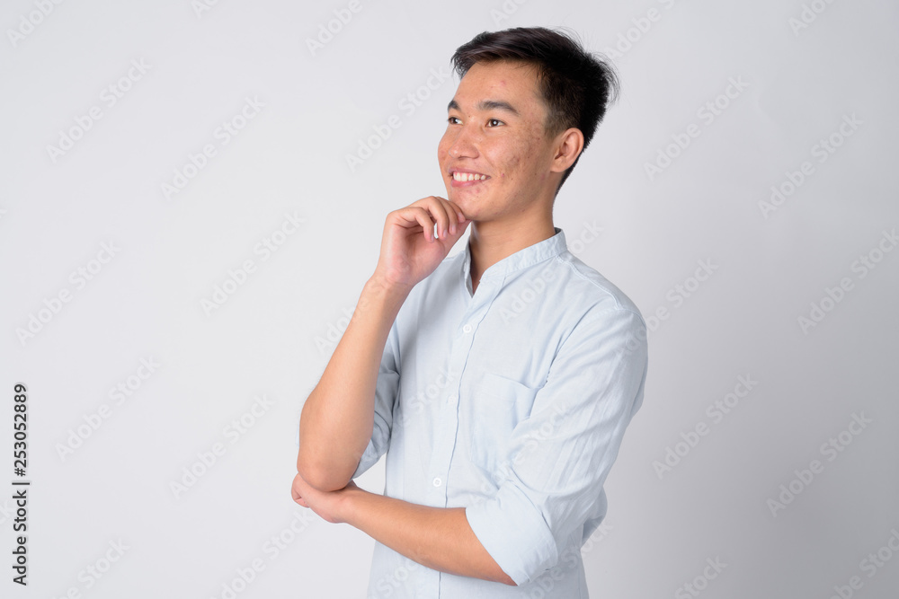 Portrait of young happy Asian businessman thinking Portrait of young happy Asian businessman thinking