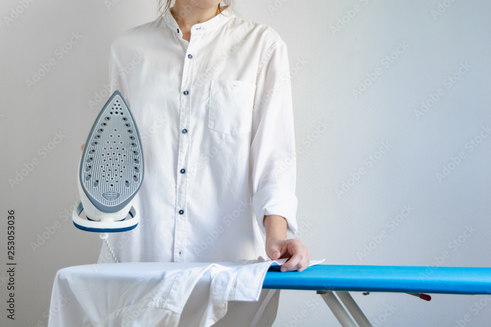 Female ironing white shirts, cleaning service, housewife. Female ironing white shirts, cleaning service, housewife.