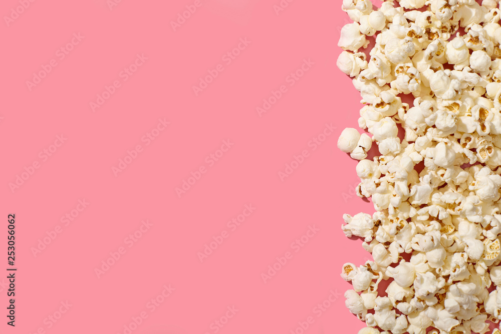 A pile of popcorn on pink background with copy space.
