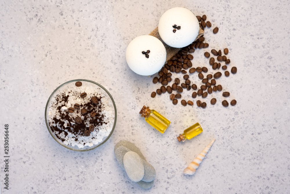 Aromatherapy and spa concept. Spa salt with coffee scent near soap, spa oil and loofah on white background top view Aromatherapy and spa concept. Spa salt with coffee scent near soap, spa oil and loofah on white background top view