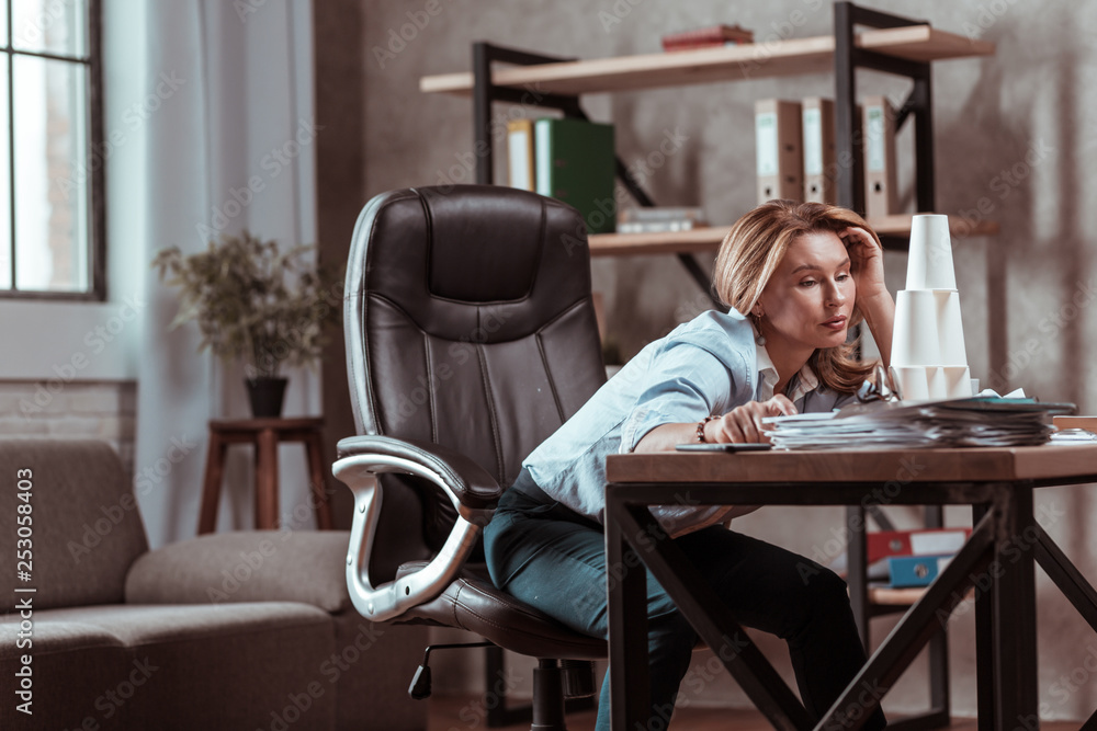 Woman wearing dark trousers and blue blouse feeling stressed Woman wearing dark trousers and blue blouse feeling stressed