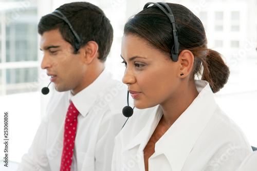 Customer service representatives at work in call center - multi ethnic team - pretty young woman - portrait