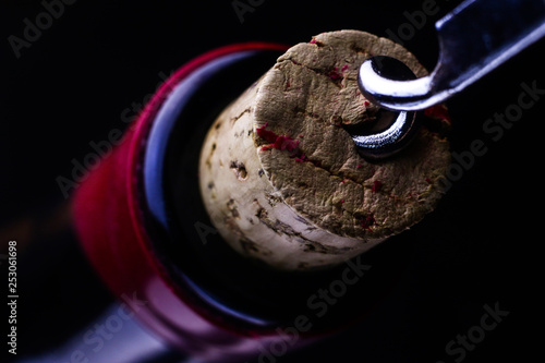 Opening of a wine bottle with corkscrew.