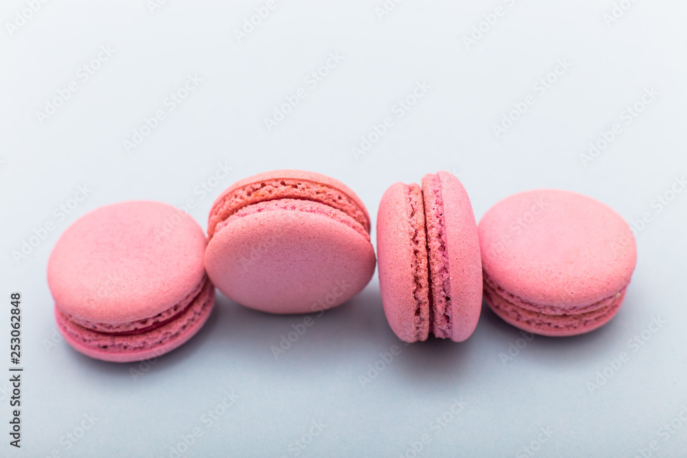 Fototapeta premium French pink macaroons cookies in rows on a light blue background