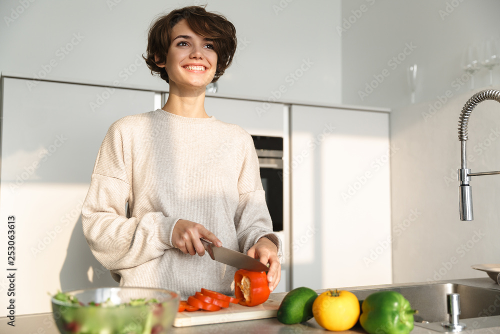 Happy young woman cooking fresh salad at the kitchen Happy young woman cooking fresh salad at the kitchen