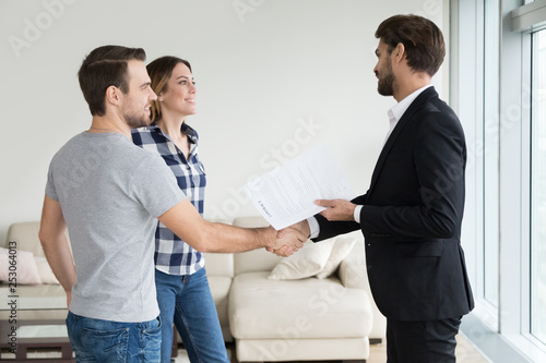 Realtor or landlord handshaking couple tenants make real estate deal photo