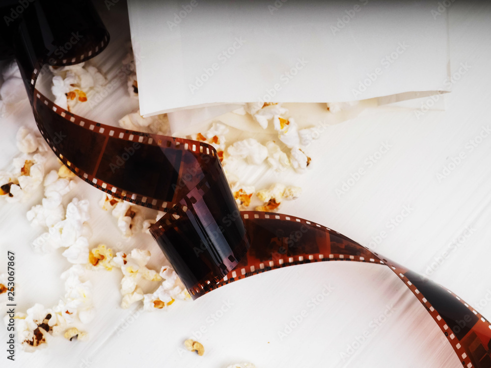 photographic film strip on white wooden background, popcorn