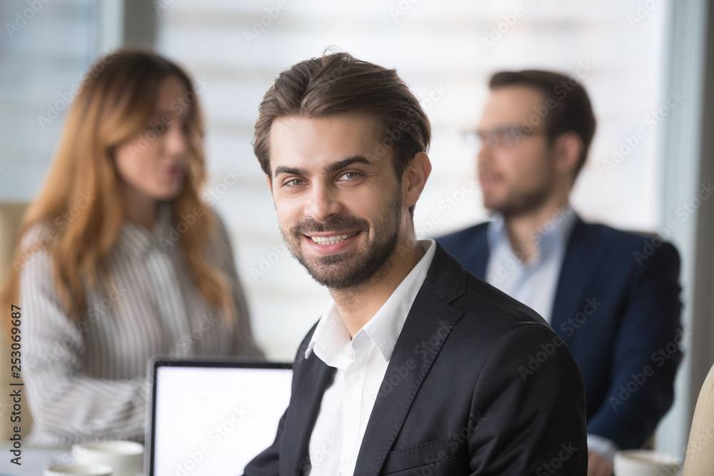 Smiling businessman in suit looking at camera posing at meeting Smiling businessman in suit looking at camera posing at meeting