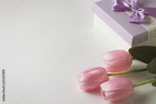 Three Tulips and a Gift Box On The White Background. Artificial flowers. Copy space