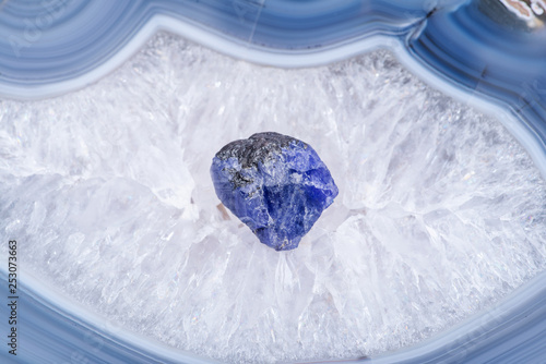 Soft blue violet rough TANZANITE from Tanzania placed on a crystalline druzy center of  Polished Large Natural Blue Lace Agate slab from Brazil. photo