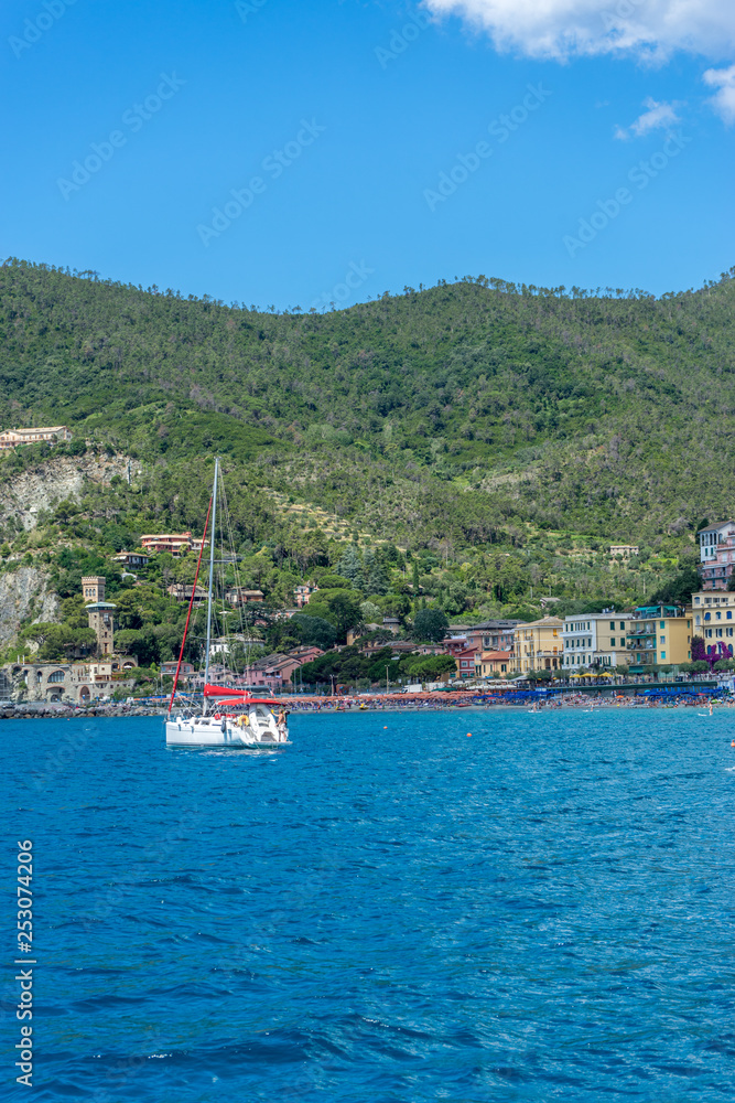 Italy, Cinque Terre, Monterosso, a small boat in a body of water with a mountain in the background