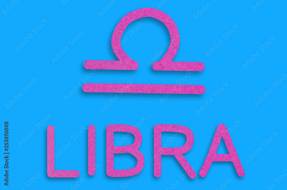 Symbol of astrological sign and word libra cut out of purple paper on blue table. Top view. Horoscope concept Symbol of astrological sign and word libra cut out of purple paper on blue table. Top view. Horoscope concept