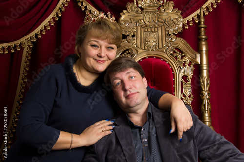 Husband and wife in a beautiful chair. Husband is king wife queen. Middle aged couple © Светлана Лазаренко