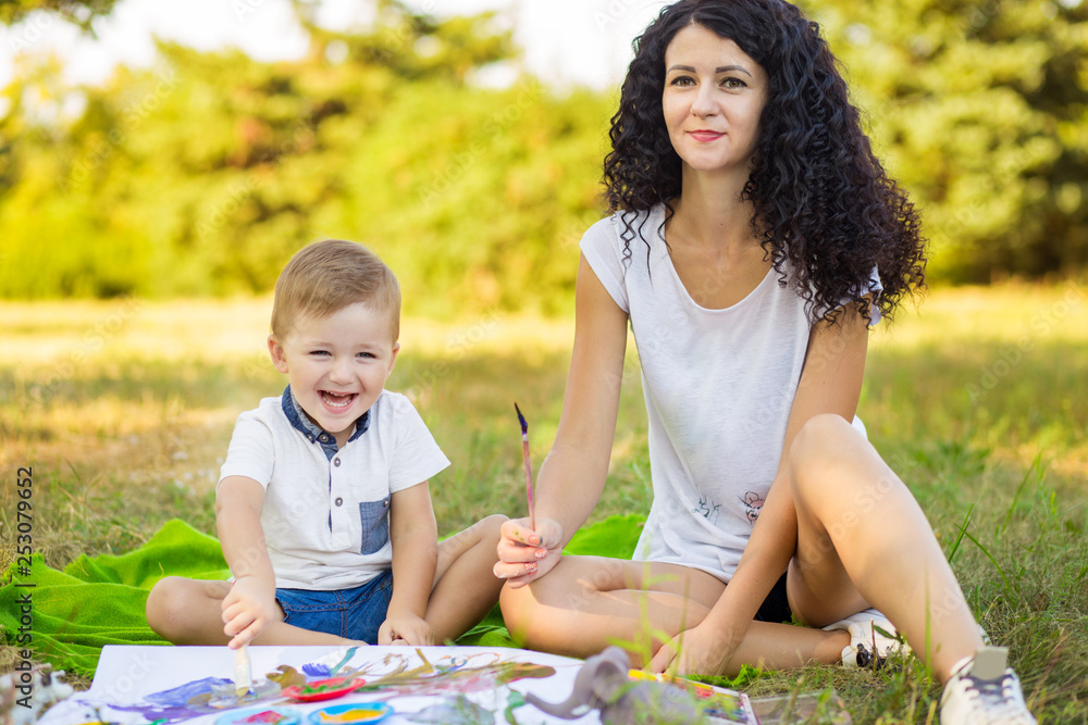 Fototapeta premium Mother and son draw outdoor. Concept of happy family