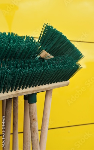 brooms on yellow background