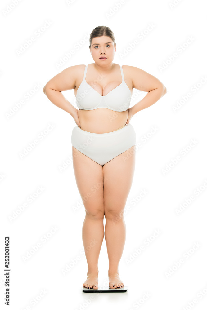 upset young overweight woman standing on scales isolated on white, lose weight concept upset young overweight woman standing on scales isolated on white, lose weight concept