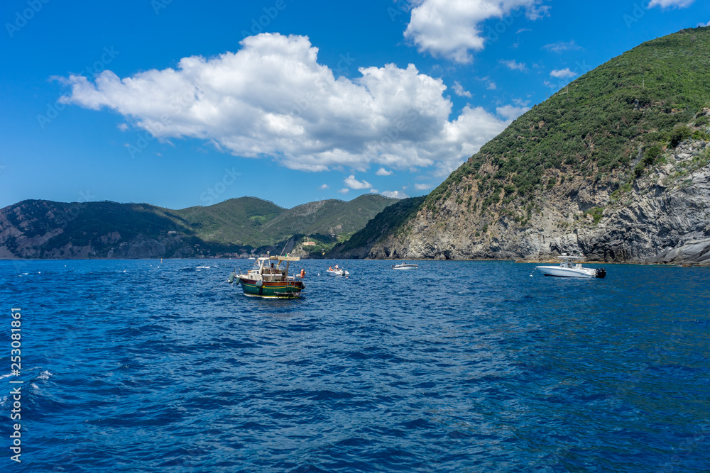 Obraz premium Italy, Cinque Terre, Monterosso, a small boat in a body of water with a mountain in the background