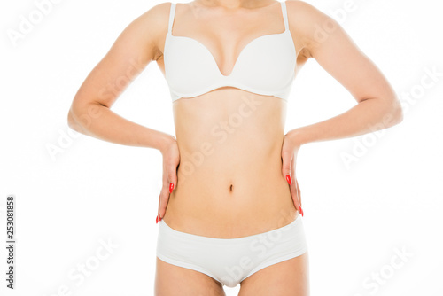 partial view of slim woman posing with hands on waist isolated on white