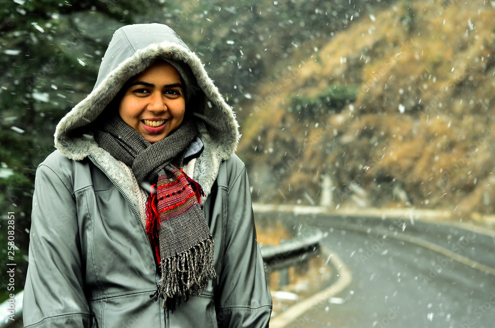Young Indian woman enjoying her first snowfall during winter holidays in Kufri, Shimla, Himachal Pradesh. It is a popular winter getaway where people come to enjoy snowfall, skiing and winter sports. Young Indian woman enjoying her first snowfall during winter holidays in Kufri, Shimla, Himachal Pradesh. It is a popular winter getaway where people come to enjoy snowfall, skiing and winter sports.