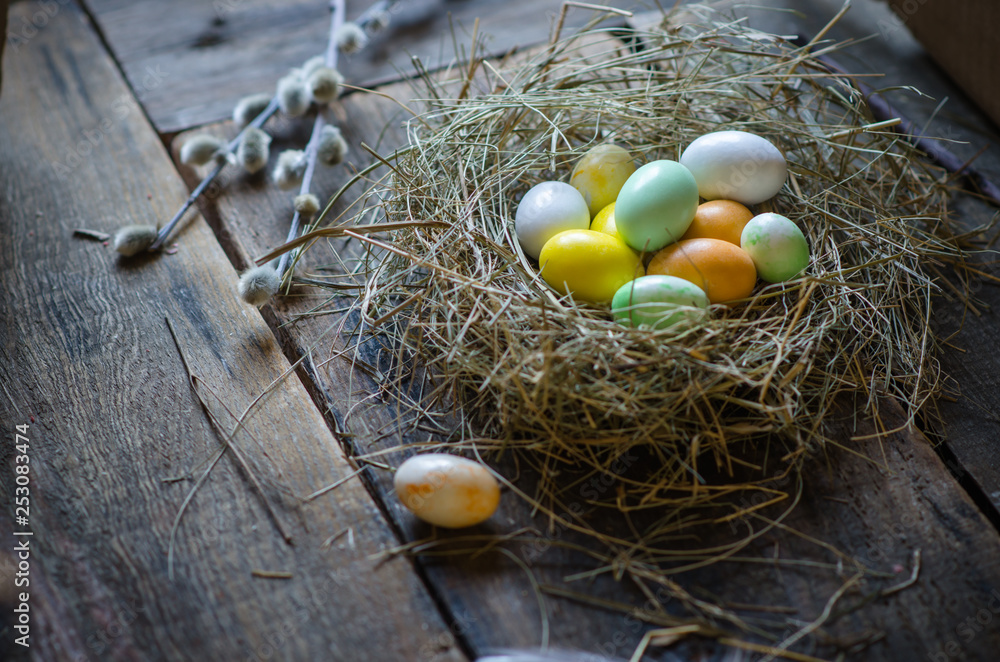 Colorful easter egg in the nest on old wood background with space for text. Rustic style. Colorful easter egg in the nest on old wood background with space for text. Rustic style.