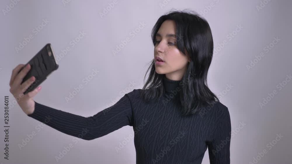 Closeup shoot of young pretty caucasian female taking selfies on the phone in front of the camera Closeup shoot of young pretty caucasian female taking selfies on the phone in front of the camera