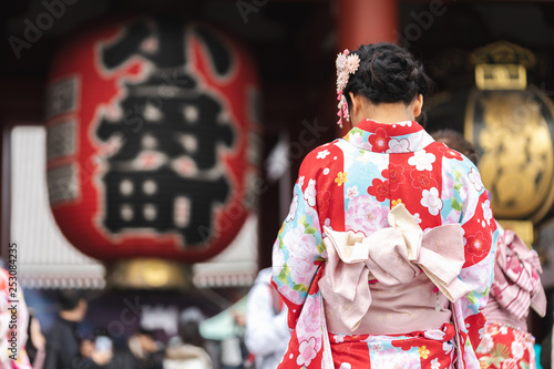 Foto Young girl wearing Japanese kimono standing in front of Sensoji Temple in Tokyo, Japan