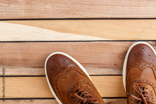 Brown men's shoes on wooden background. Top view