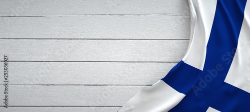 Canvastavla Finland flag, on top of white wood. Wrinkled fabric.