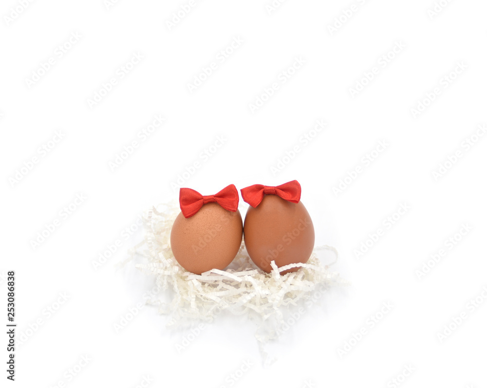 Two brown eggs together on the white crumped paper cuts with the red bows Two brown eggs together on the white crumped paper cuts with the red bows