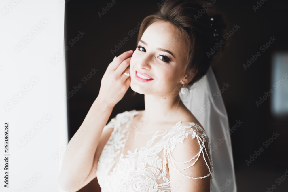 Gorgeous bride in robe posing and preparing for the wedding ceremony face in a room Gorgeous bride in robe posing and preparing for the wedding ceremony face in a room