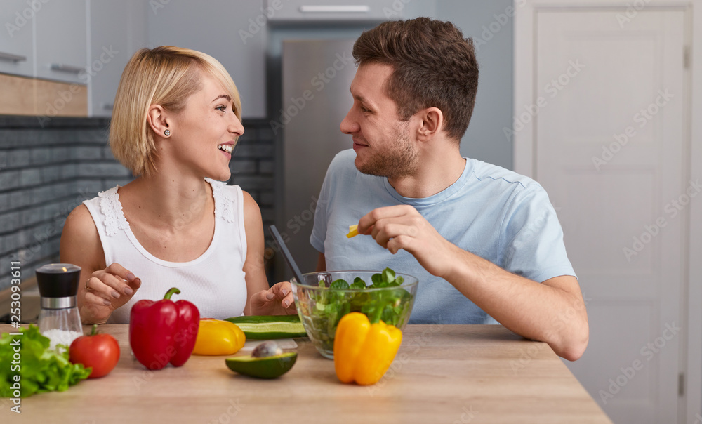 Happy man and woman preparing vegetable salad Happy man and woman preparing vegetable salad
