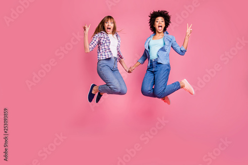 Full length body size view of two person nice attractive charming cheerful funny crazy funky girls holding hands showing v-sign isolated over pink pastel background