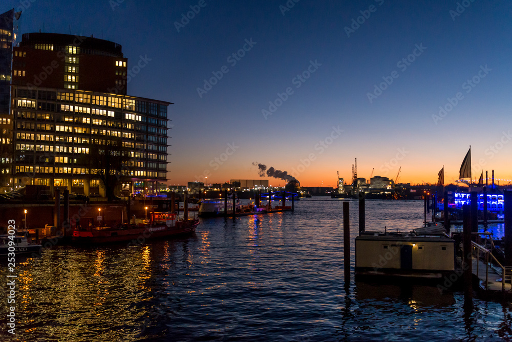 Illuminated buildings at night in HafenCity in the harbour on the Elbe river, Hamburg, Germany