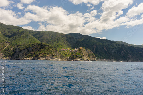 Italy, Cinque Terre, Monterosso, a large body of water with a mountain in the background © SkandaRamana