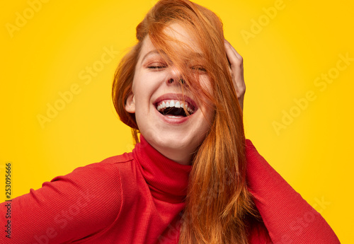 Laughing model touching ginger hair