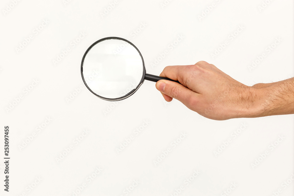 Hand holding magnifying glass isolated on white background Hand holding magnifying glass isolated on white background