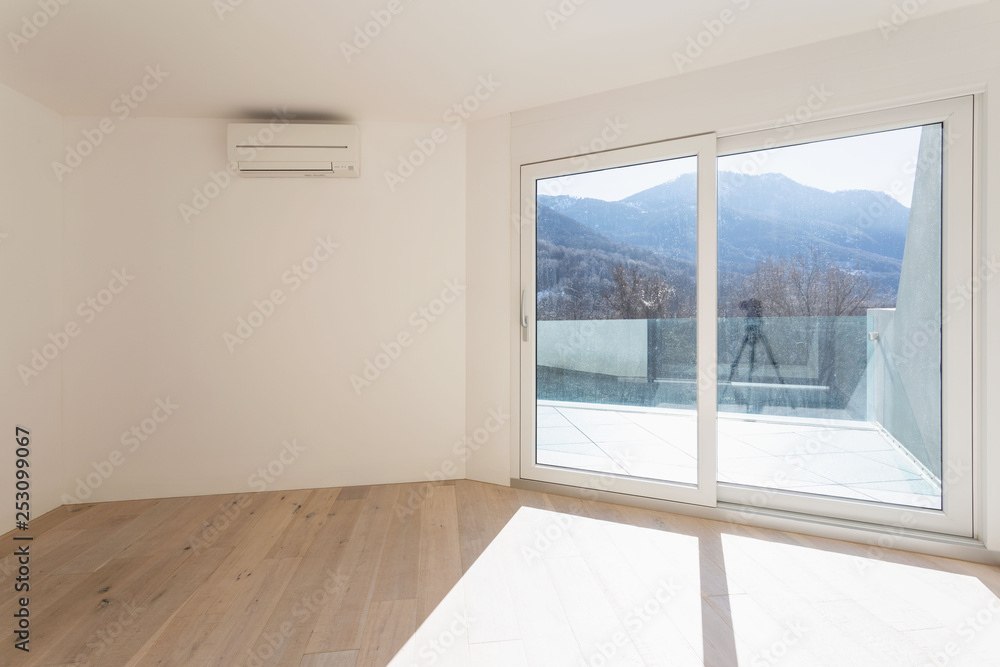 Obraz premium Empty room with white walls and windows overlooking the mountains