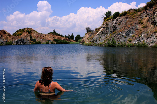 Young, beautiful woman model standing in a lake of a old sandmining place on holiday in Spain © pangamedia