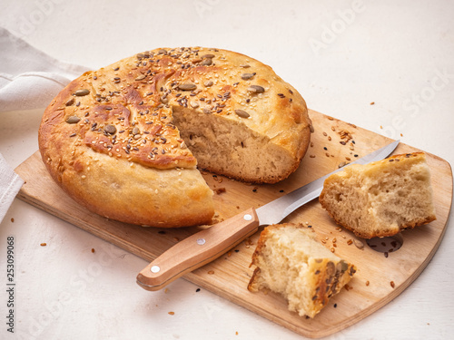 Homemade bread in cut and sliced chunks on a wooden kitchen board