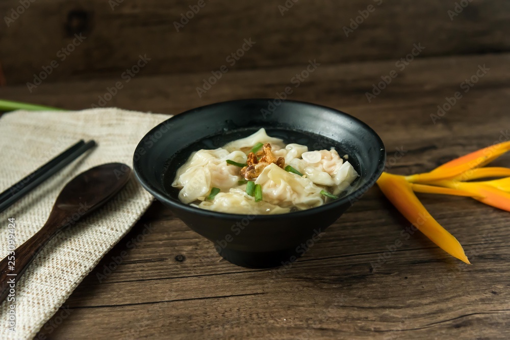 Shrimp wonton with braised pork in soup on wooden table - Asian food style / Select focus image Shrimp wonton with braised pork in soup on wooden table - Asian food style / Select focus image