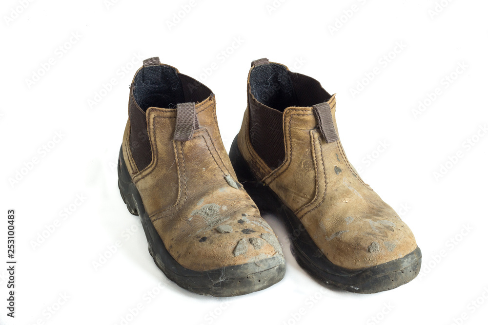pair of old used construction boots isolated on white