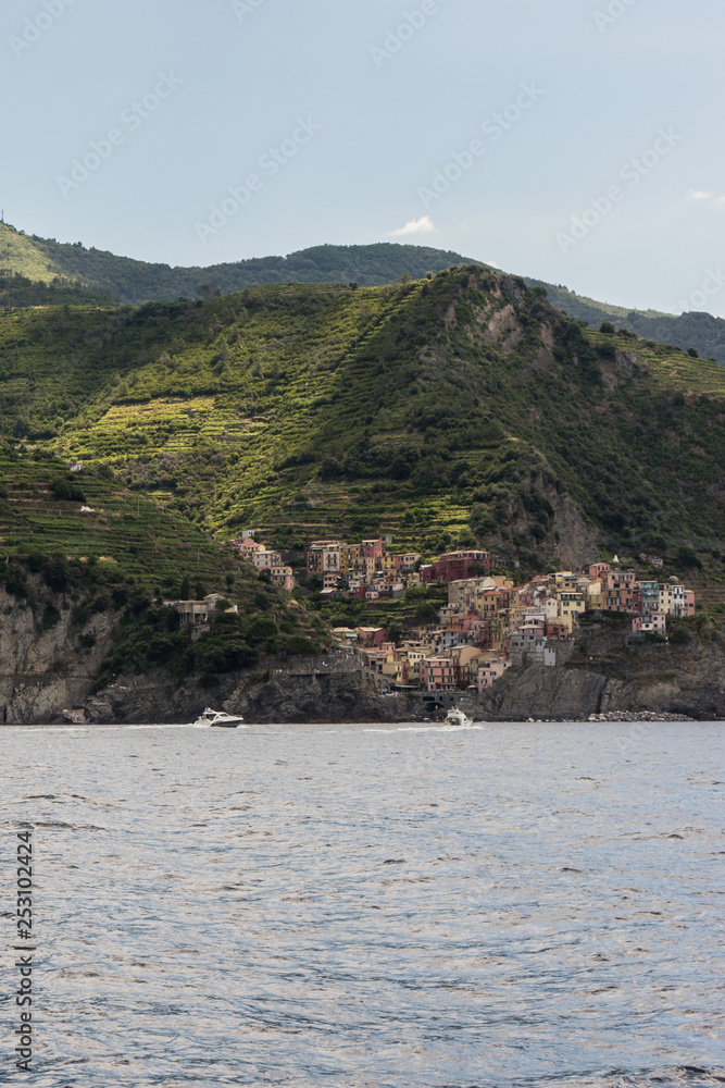 Italy, Cinque Terre, Monterosso, a body of water with a mountain in the background