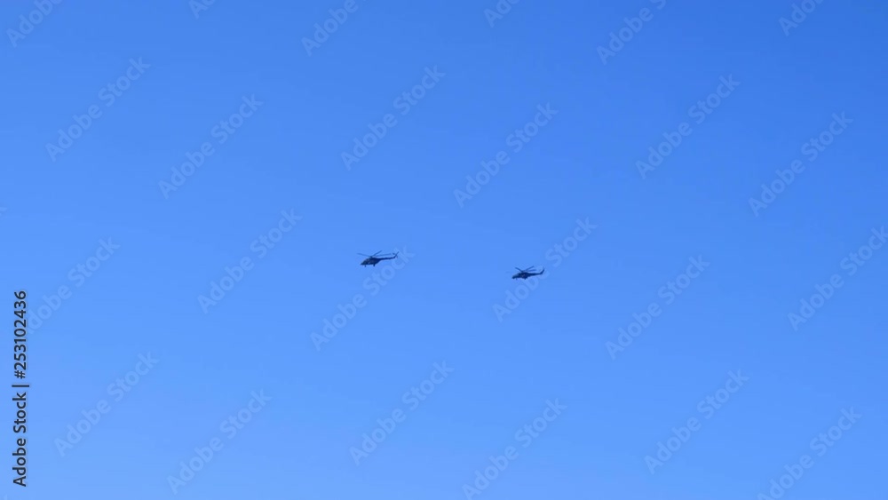 Two helicopters fly in the blue clear sky in sunny day. Two helicopters fly in the blue clear sky in sunny day.